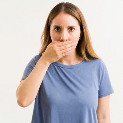 Woman holding mouth because of bad breath