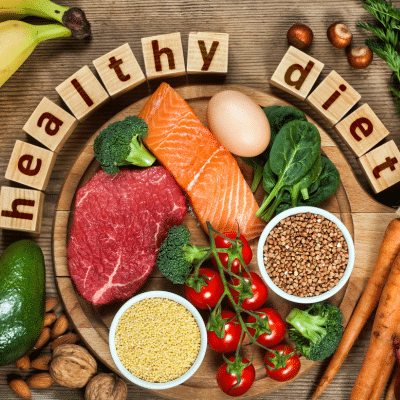 Wooden letters that spell out healthy diet on a wooden table with healthy foods, representing diet