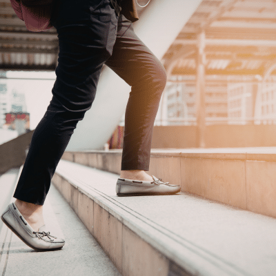 Person walking up outdoor stairs, representing how to maintain oral hygiene on the go